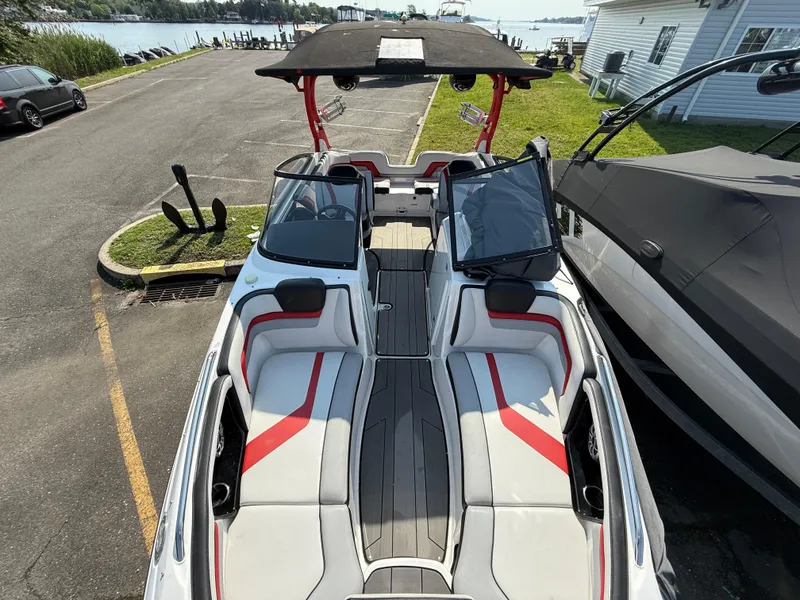 Slide: The Image of 2019 Yamaha Boats 242X E-Series, sleek design, spacious seating, docked near waterfront. - 23