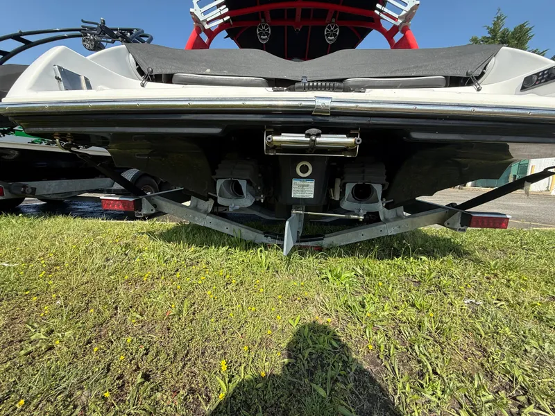 Slide: The Image of 2019 Yamaha Boats 242X E-Series rear view on grass, showcasing dual engines. - 5