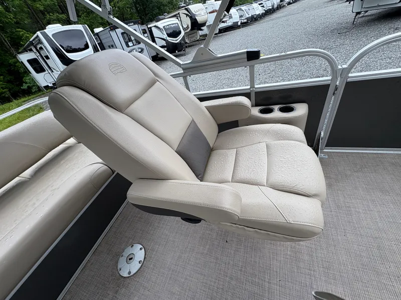 Slide: The Image of 2022 Sun Tracker PARTY BARGE boat seat with cup holders, surrounded by RVs. - 10