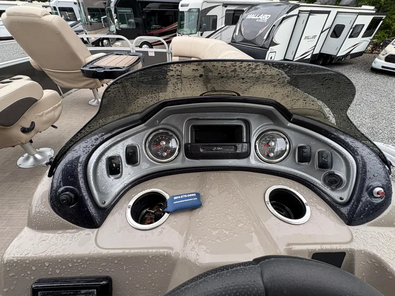 Slide: The Image of 2022 Sun Tracker PARTY BARGE dashboard with gauges and controls, wet from rain. - 17
