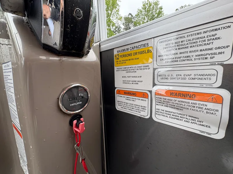 Slide: The Image of 2022 Sun Tracker PARTY BARGE capacity and warning labels with ignition key and hour meter. - 22