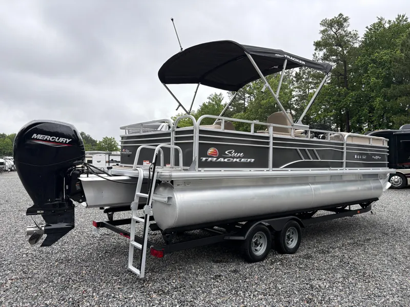 Slide: The Image of 2022 Sun Tracker PARTY BARGE pontoon boat with Mercury outboard motor on a trailer. - 4