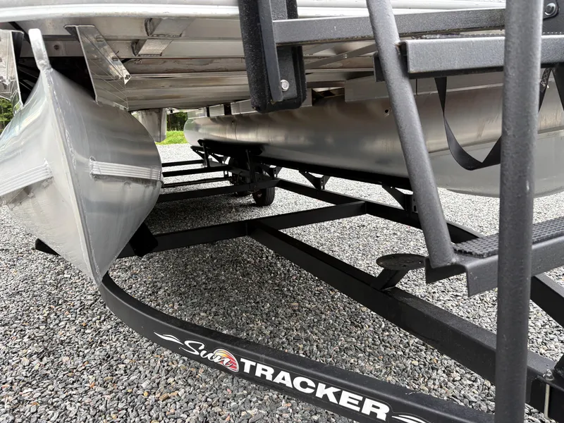 Slide: The Image of 2022 Sun Tracker PARTY BARGE pontoon boat on a trailer, parked on gravel. - 6