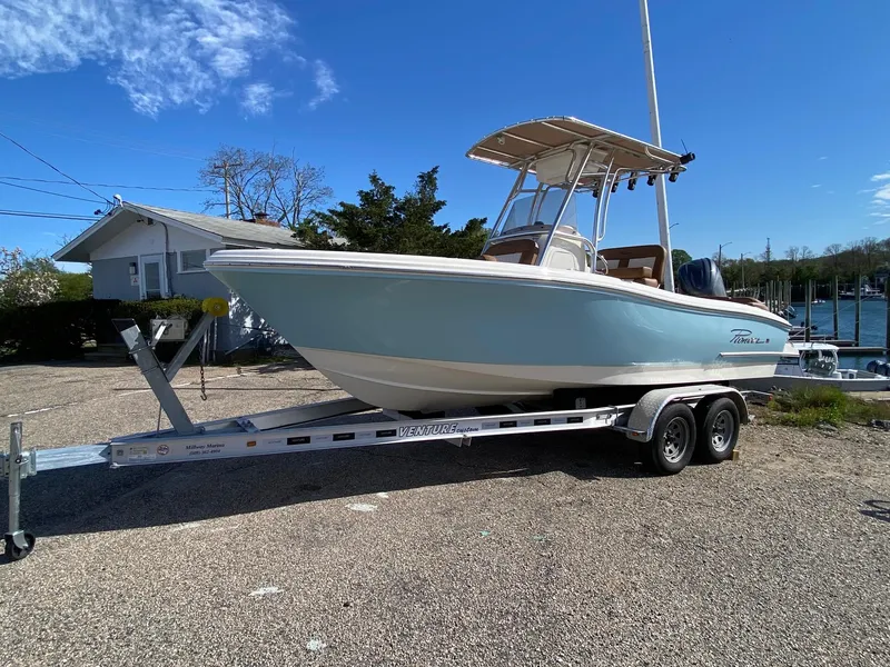 The Image of 2025 Pioneer 202 Islander boat on trailer, light blue hull, clear sky background. - 0