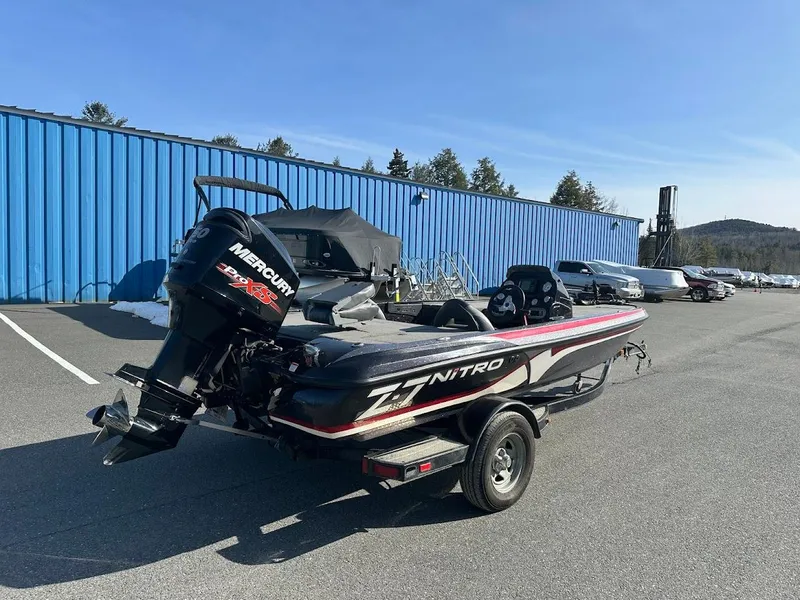 Slide: The Image of 2013 Nitro Z7 18' boat with Mercury engine, parked outdoors near blue building. - 1