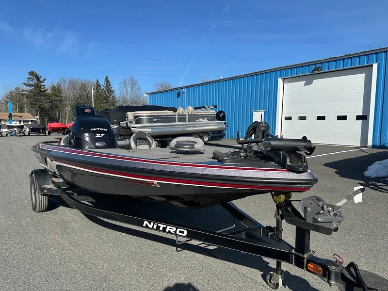 Slide: The Image of 2013 Nitro Z7 18' boat on trailer, parked near blue building. - 2