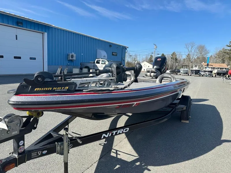 Slide: The Image of 2013 Nitro Z7 18' boat on trailer, parked outdoors near blue building. - 3