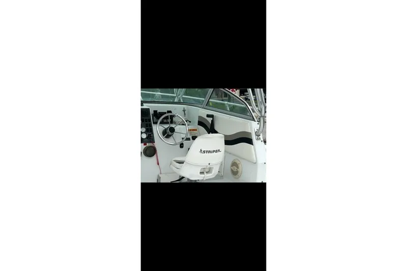 Slide: The Image of 2000 Seaswirl Striper 2600 Walkaround O/B boat interior with steering wheel and seat. - 7