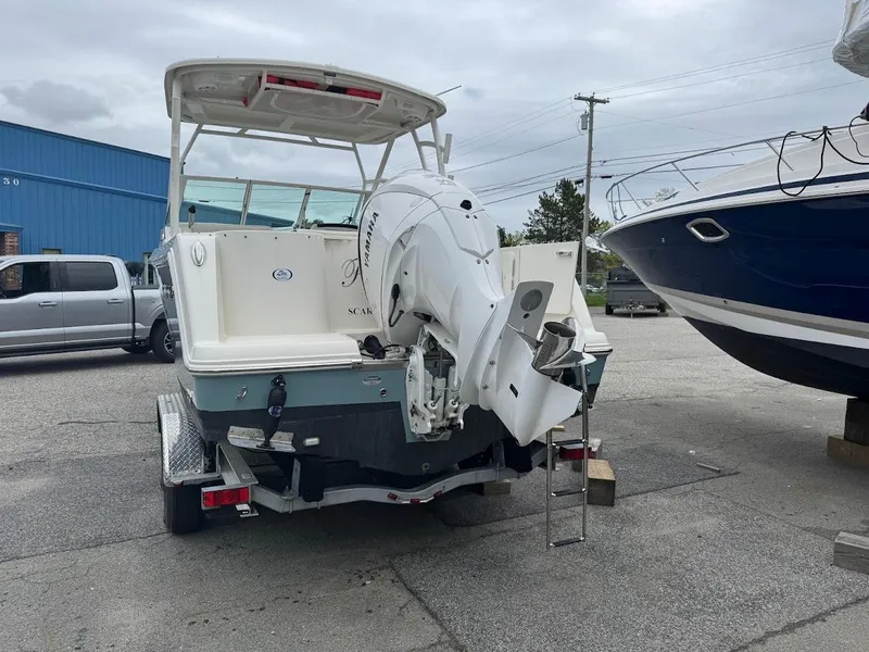 Slide: The Image of 2023 Sailfish 245 DC boat with outboard motor on trailer in marina. - 1