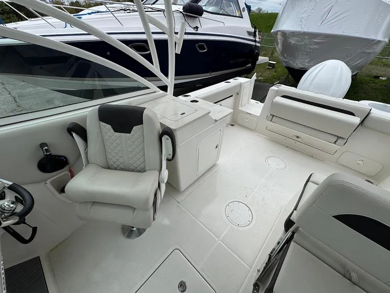 Slide: The Image of 2023 Sailfish 245 DC boat interior with white seating and storage compartments. - 10