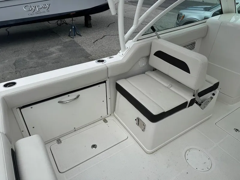Slide: The Image of 2023 Sailfish 245 DC boat interior with white seating and storage compartments. - 4