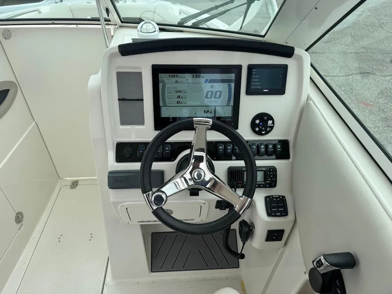 Slide: The Image of 2023 Sailfish 245 DC boat dashboard with steering wheel and digital display. - 6