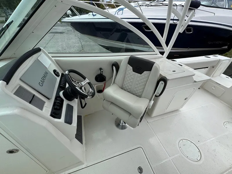 Slide: The Image of 2023 Sailfish 245 DC boat cockpit with Garmin navigation system and comfortable seating. - 9