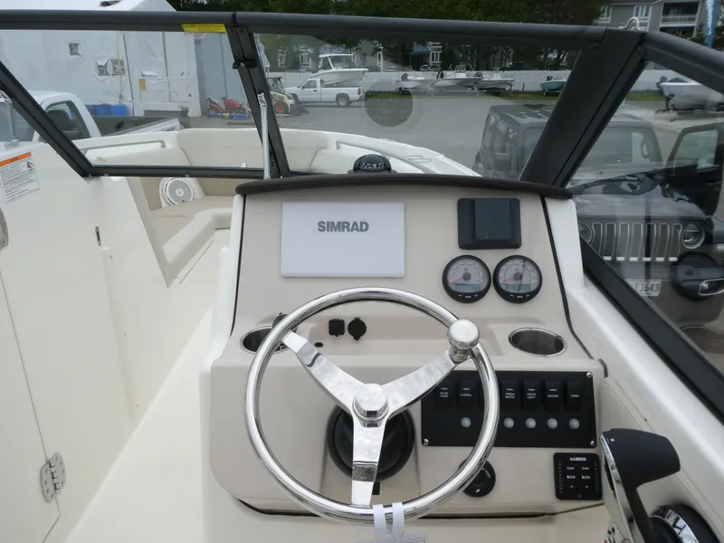 Slide: The Image of 2025 Boston Whaler 210 Vantage boat dashboard with steering wheel and Simrad display. - 12