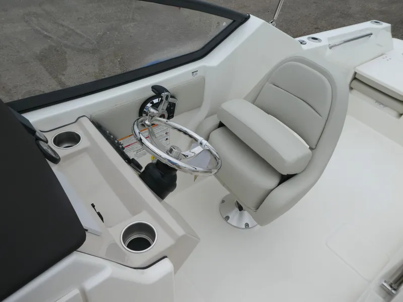 Slide: The Image of 2025 Boston Whaler 210 Vantage boat cockpit with steering wheel and comfortable seating. - 13