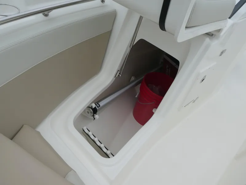 Slide: The Image of Storage compartment in 2025 Boston Whaler 210 Vantage boat with red bucket and equipment. - 16