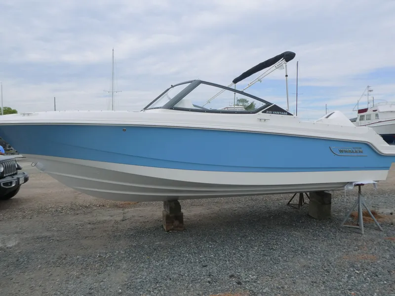 Slide: The Image of 2025 Boston Whaler 210 Vantage boat in light blue, displayed on a gravel lot. - 4