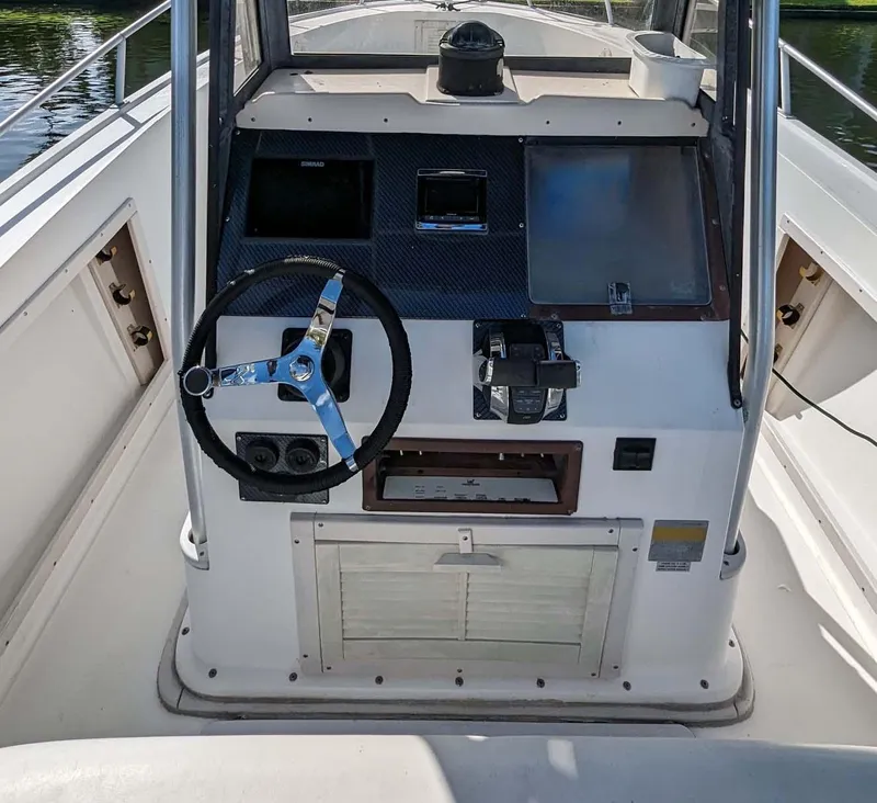 Slide: The Image of 1991 Mako 261 boat helm with steering wheel and control panel. - 4