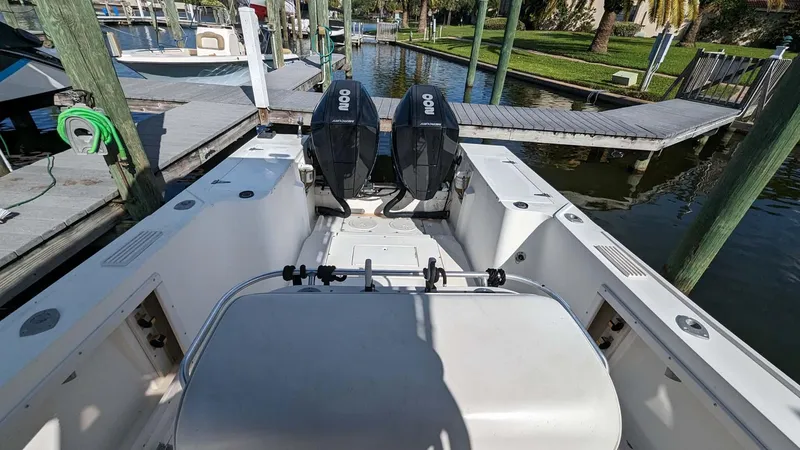 Slide: The Image of 1991 Mako 261 boat with dual outboard motors docked at a marina. - 8