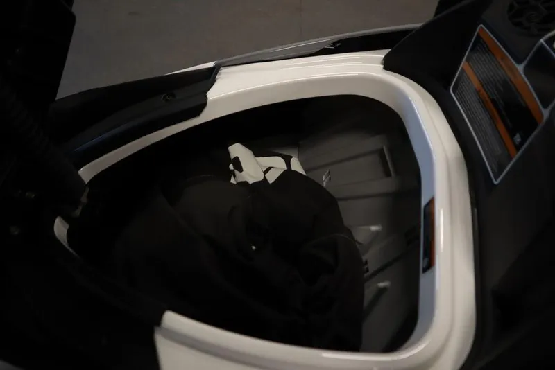 Slide: The Image of 2024 Sea-Doo GTI™ 130 storage compartment with black interior and visible safety instructions. - 3