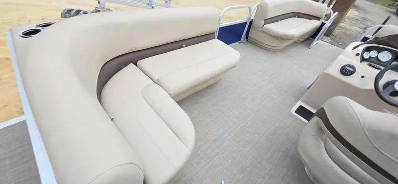 Slide: The Image of 2017 Sun Tracker Party Barge 18 DLX interior with beige seating and steering console. - 10