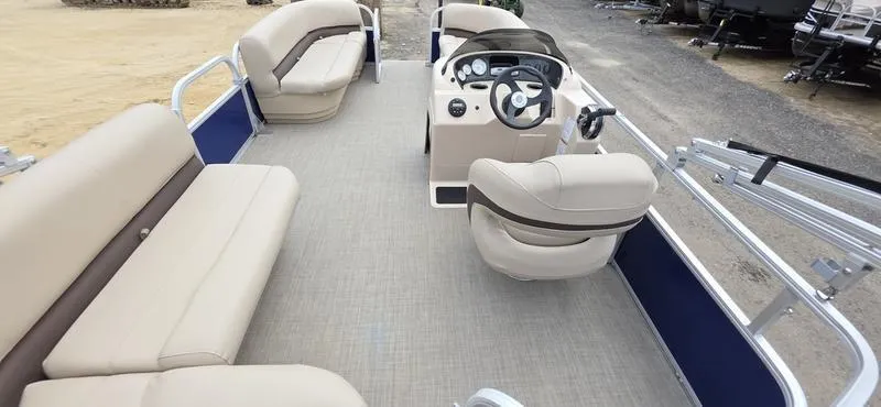 Slide: The Image of 2017 Sun Tracker Party Barge 18 DLX pontoon boat interior with beige seating and steering console. - 11