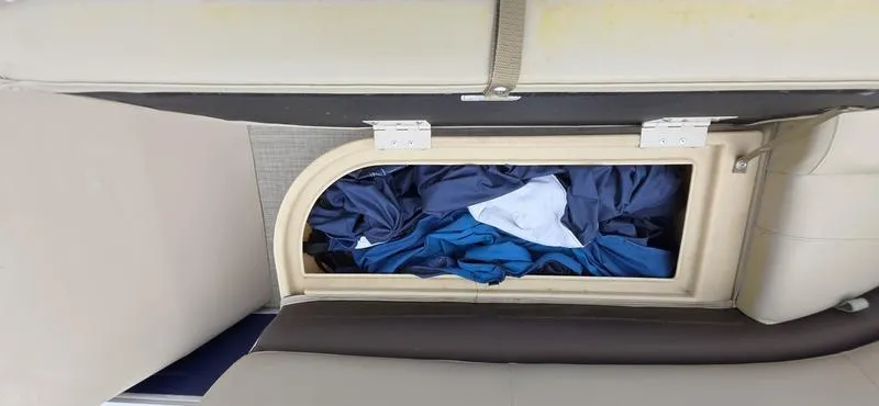 Slide: The Image of Storage compartment on a 2017 Sun Tracker Party Barge 18 DLX with clothes inside. - 15