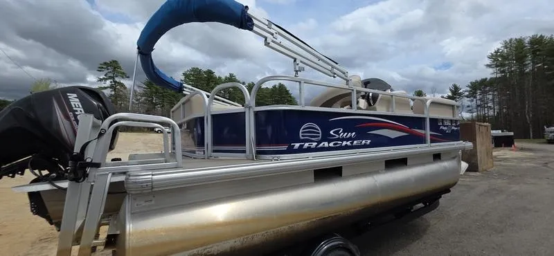 Slide: The Image of 2017 Sun Tracker Party Barge 18 DLX pontoon boat on trailer, outdoors under cloudy sky. - 3