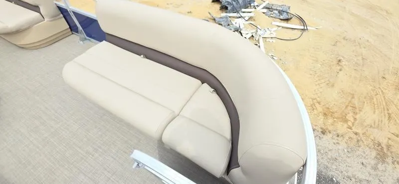 Slide: The Image of 2017 Sun Tracker Party Barge 18 DLX beige seating on sandy terrain. - 6