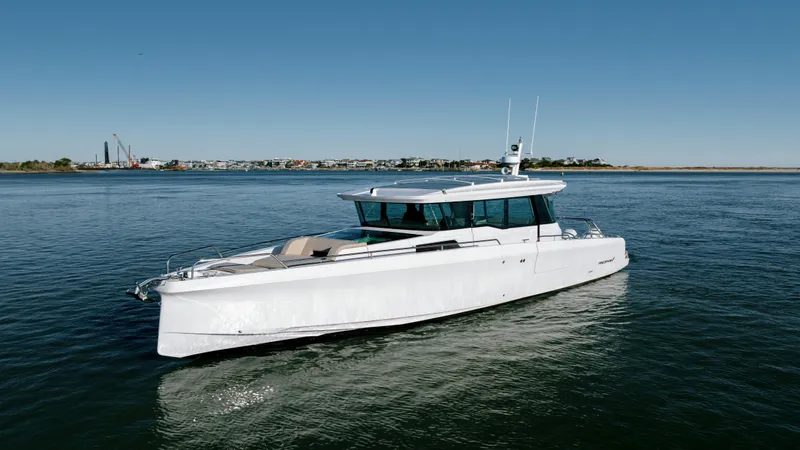 Slide: The Image of 2025 Axopar 45 XC Cross Cabin boat cruising on calm waters under clear blue sky. - 3