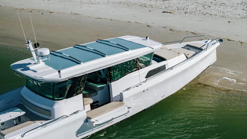 Slide: The Image of 2025 Axopar 45 XC Cross Cabin boat on sandy beach, sleek design, modern features. - 5