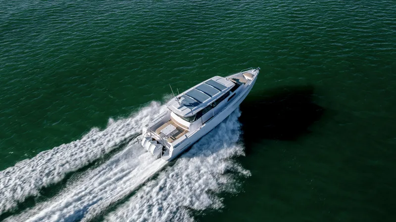 Slide: The Image of 2025 Axopar 45 XC Cross Cabin cruising on open water, aerial view. - 8