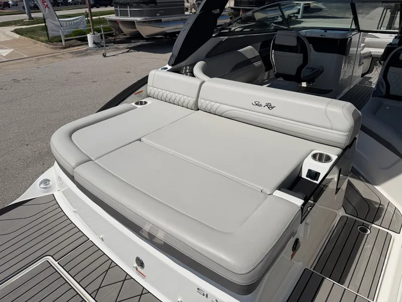 Slide: The Image of The image shows the rear of a Sea Ray SLX 260 boat with a large padded sunbed and cup holders. - 24