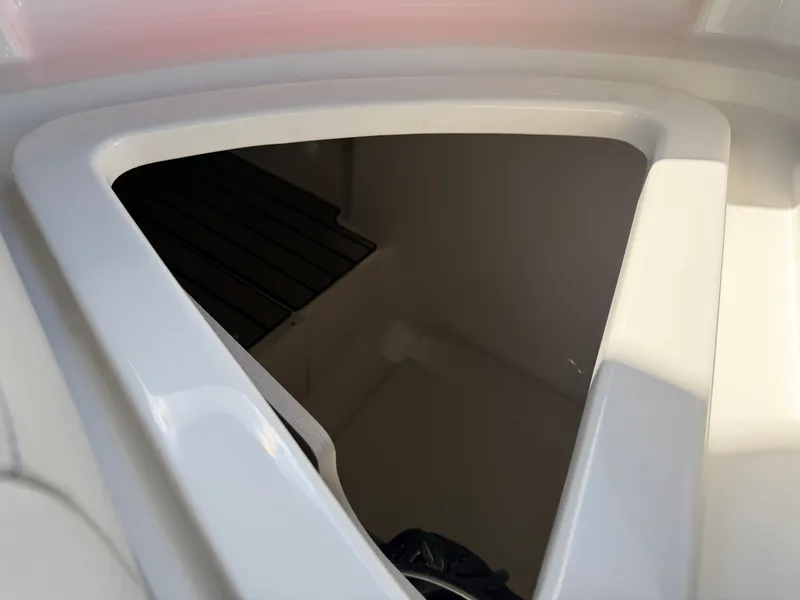 Slide: The Image of A triangular storage compartment inside a boat with white walls and a dark floor. - 48