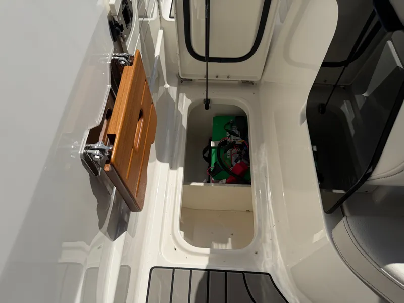 Slide: The Image of A view into the storage area of a 2026 Sea Ray SLX 260 boat with a foldable seat. - 33
