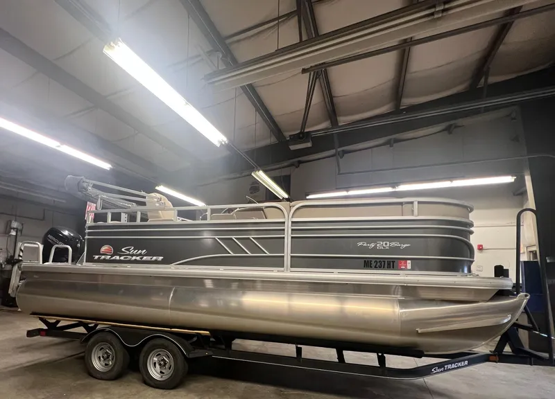 The Image of 2020 Sun Tracker Party Barge 20 DLX pontoon boat on trailer in indoor storage. - 0