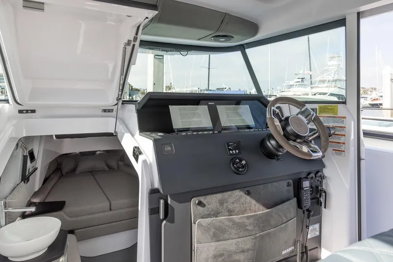 Slide: The Image of 2023 Axopar 37 XC Cross Cabin interior with steering wheel and cabin view. - 15