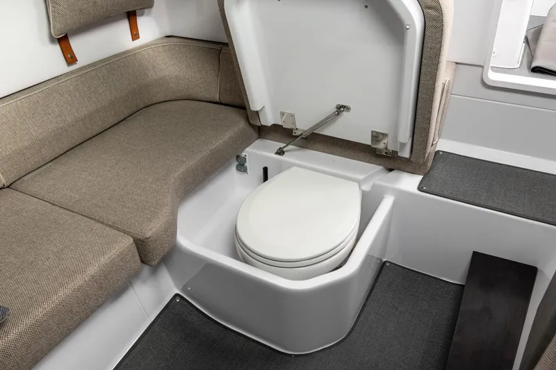 Slide: The Image of 2023 Axopar 37 XC Cross Cabin interior with toilet and seating area. - 23