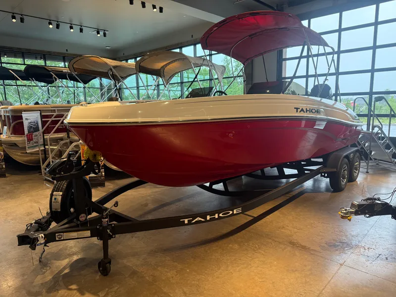 Slide: The Image of 2025 Tahoe T21 boat with red hull on display in showroom. - 2