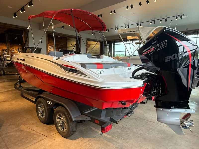 Slide: The Image of 2025 Tahoe T21 boat with red hull and Mercury Pro XS engine in showroom. - 4