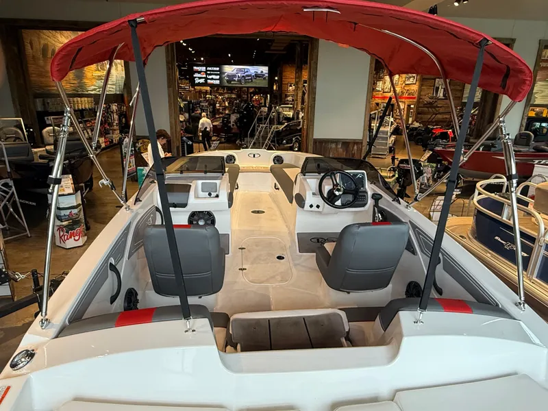 Slide: The Image of 2025 Tahoe T21 boat interior with red canopy, displayed in showroom. - 5