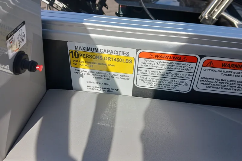 Slide: The Image of Warning labels and capacity information on a 2025 Ranger Reata 220FC boat. - 9