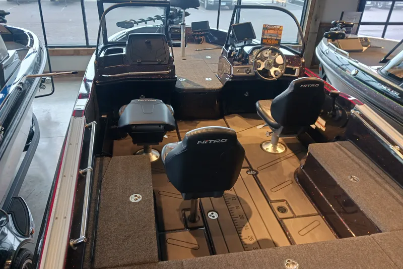 Slide: The Image of 2025 Nitro ZV20 boat interior with seating and control panel in showroom. - 12