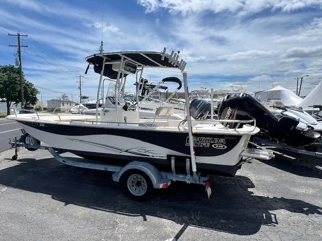 Slide: The Image of 2016 Carolina Skiff 218 DLV boat on trailer under blue sky. - 0