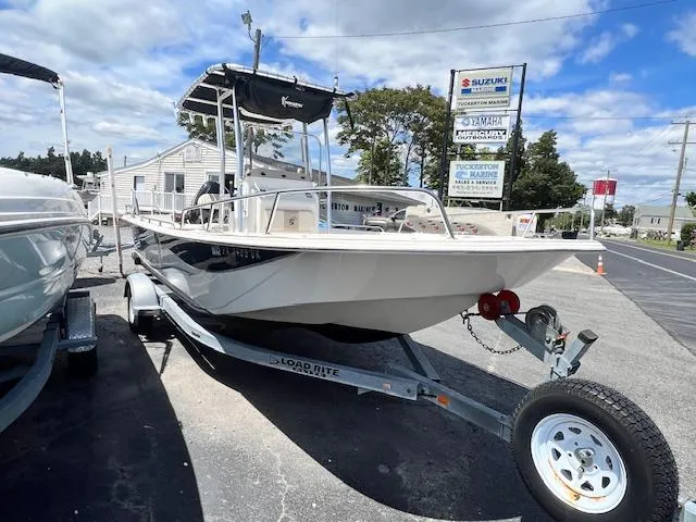 Slide: The Image of 2016 Carolina Skiff 218 DLV boat on trailer, parked outdoors under cloudy sky. - 1