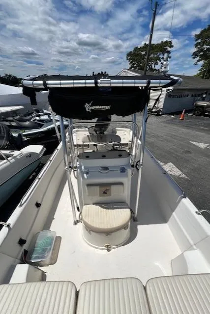 Slide: The Image of 2016 Carolina Skiff 218 DLV boat with center console and T-top, parked outdoors. - 11