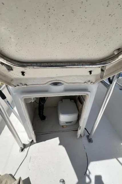 Slide: The Image of 2016 Carolina Skiff 218 DLV boat interior with storage compartment and portable toilet. - 12
