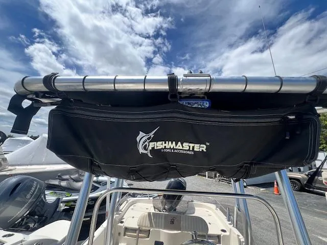 Slide: The Image of 2016 Carolina Skiff 218 DLV with Fishmaster T-top under a partly cloudy sky. - 14