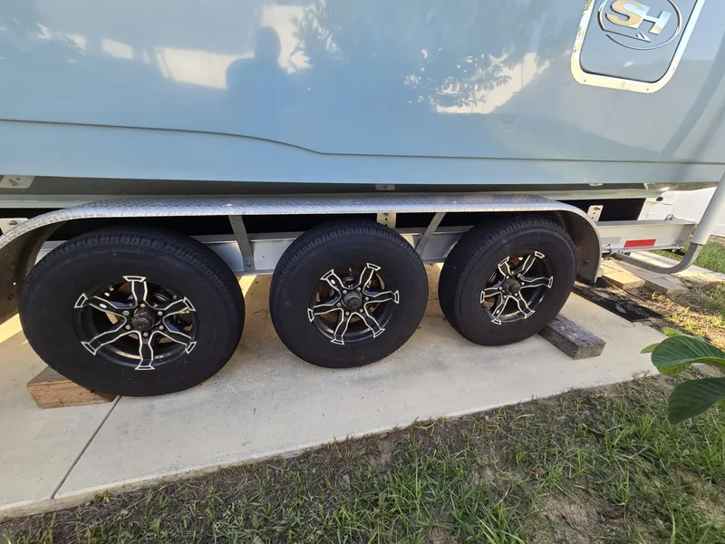 Slide: The Image of 2022 Sea Hunt Gamefish 30 trailer with three black wheels on a concrete pad. - 17