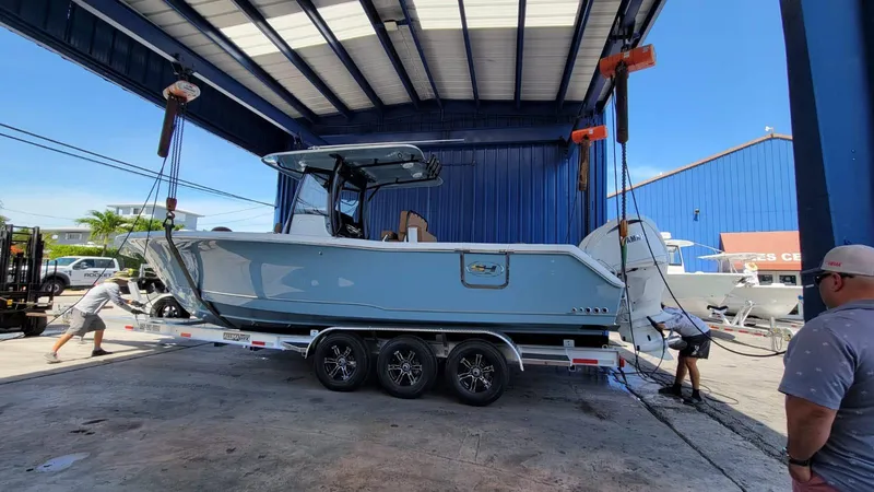 Slide: The Image of 2022 Sea Hunt Gamefish 30 boat on trailer in a covered dock area. - 22